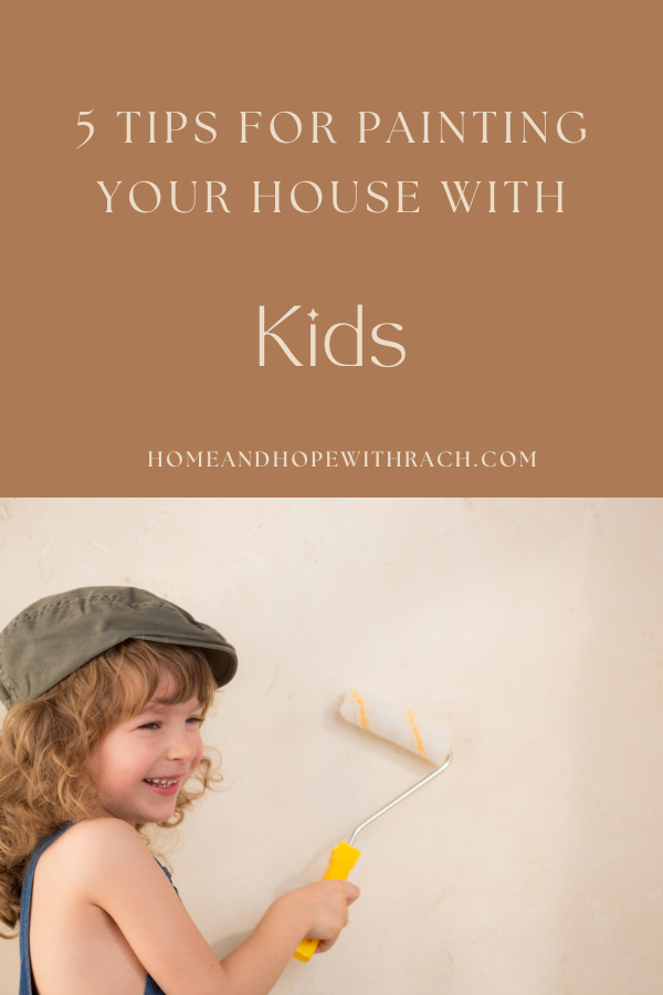 child with paint roller laughing